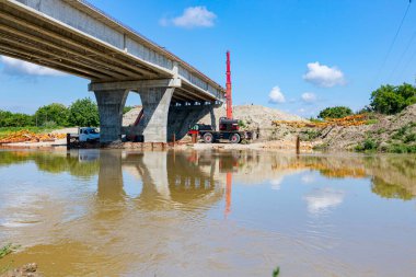 View of the unfinished bridge, road over river is under construction, building site.