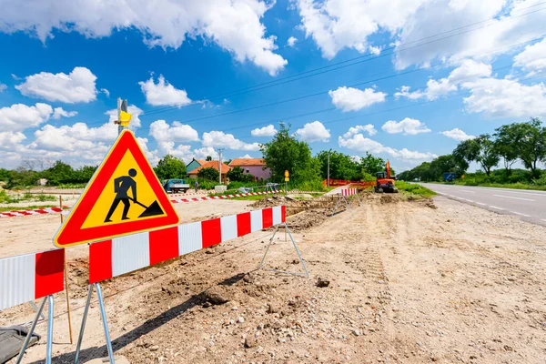 Work in progress, triangle sign with boundary, caution symbol, trench is on construction site.