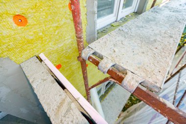 Shot above is on the place of scaffold for trampling attached to the structure. Applying insulation material, rock wool on the residential building is in progress. 
