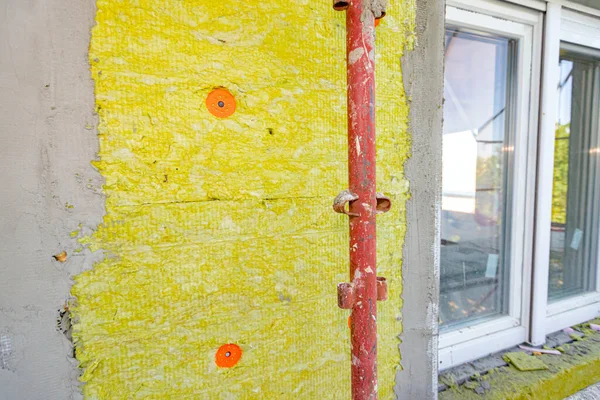 Applied thermal isolation stone wool on the brick wall of residential building under construction, heat isolation with mineral wool.
