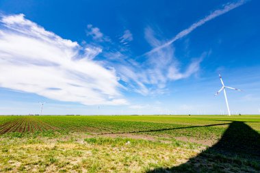 Rüzgar jeneratörü, türbinler, dönen bıçaklar, pervaneler, yenilenebilir temiz enerji kinetik enerjiyi dönüştüren uzun gölgeler.