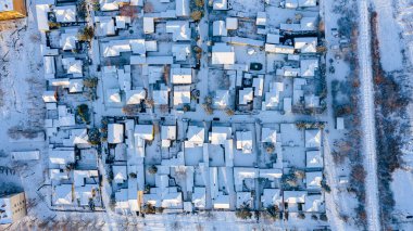 Üst manzara evlerin çatılarında kardan beyaz, kışın soğuk şehir manzarası..  