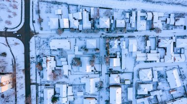 Üst manzara evlerin çatılarında kardan beyaz, kışın soğuk şehir manzarası..  