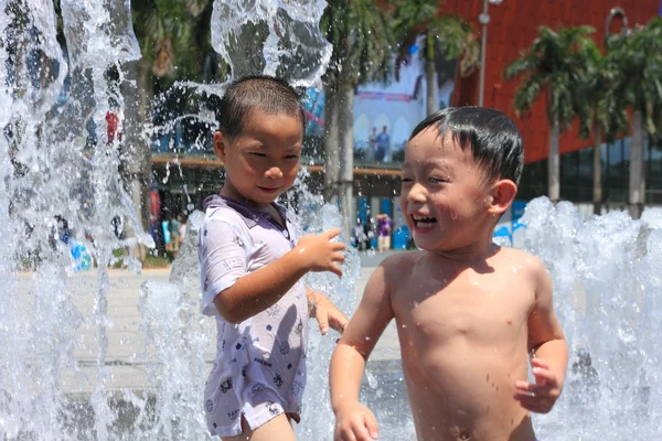 Kinderen spelen in water fonteinen — Stockfoto