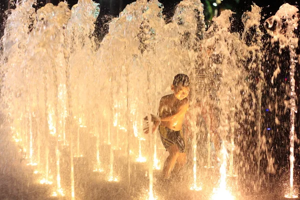 Un ragazzo che gioca nelle fontane — Foto Stock