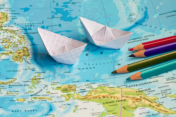 Paper ships on the geography map