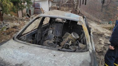 Rusya 'nın Ukrayna' ya karşı savaşı. Bir Rus roketi tarafından vurulduktan sonra konut binasının avlusunda yanmış bir araba. Roket parçası 9K58 