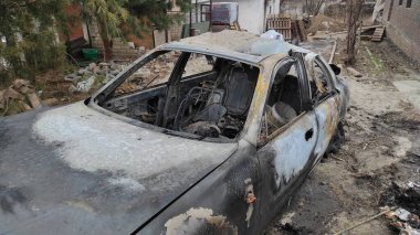 Rusya 'nın Ukrayna' ya karşı savaşı. Bir Rus roketi tarafından vurulduktan sonra konut binasının avlusunda yanmış bir araba. Roket parçası 9K58 