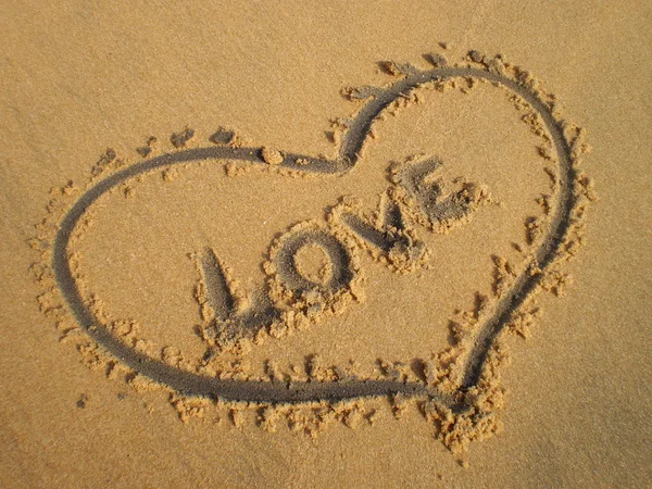 Heart drawn in the sand and the word Love — Stock Photo, Image