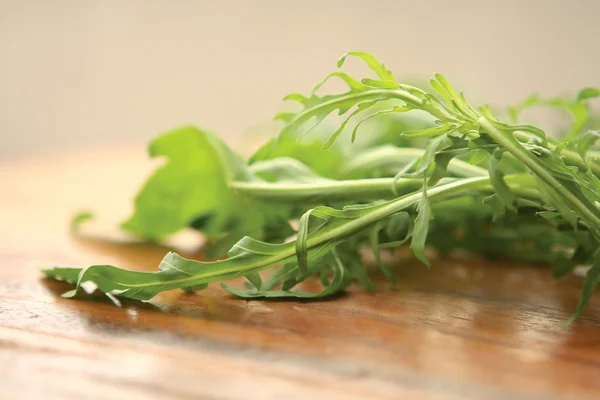 Fresh Green Rucola on a wooden board — Stock Photo, Image