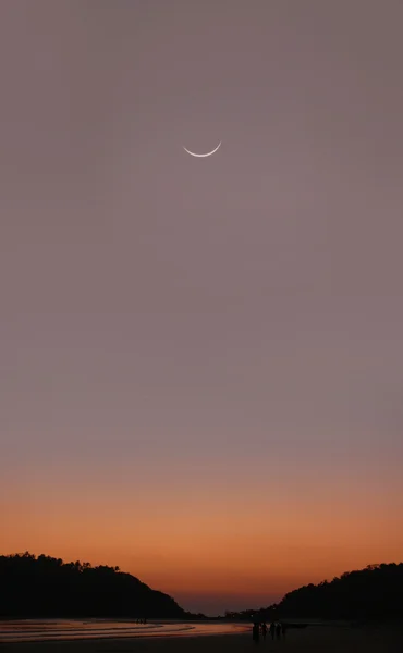 Luna joven al atardecer en la India - Goa - Palolem playa —  Fotos de Stock