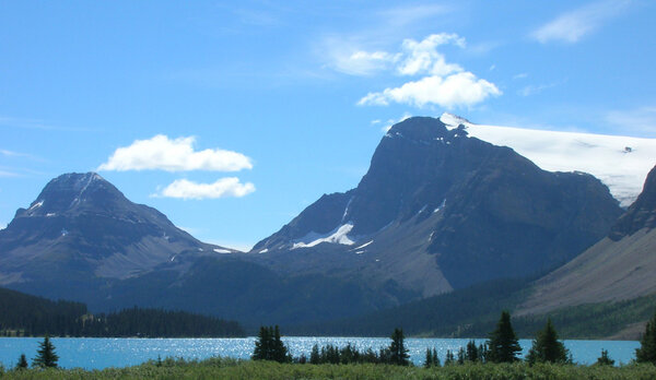 Canadian Rockies, grass foreground, lake, then mountains with gl
