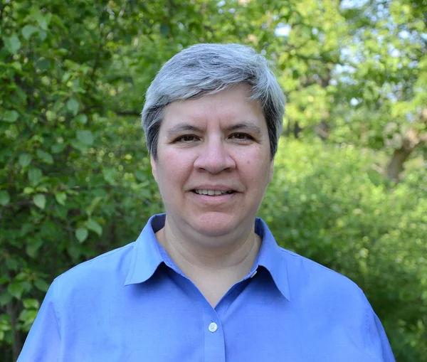 MIddle aged woman head shot in garden — Stock Photo, Image