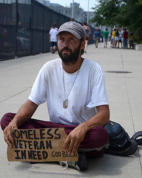 Hajléktalan veterán megáll, mint ő könyörög a pénz Stock Kép