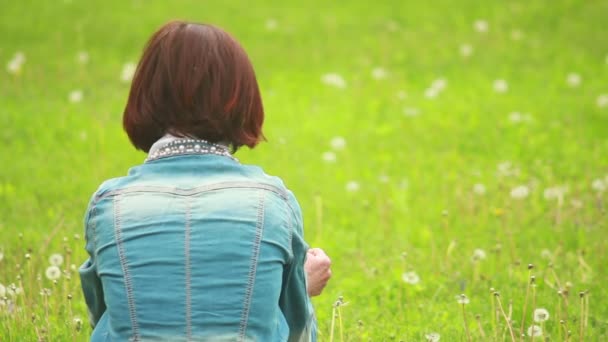 Yeşil çimenlerin üzerinde oturan kız — Stok video