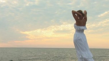 Plajda beyaz elbiseli bir kadın