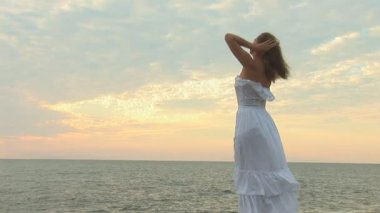 Plajda beyaz elbiseli bir kadın