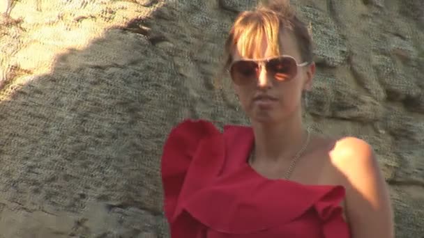 Donna in abito rosso passeggiando attraverso il muro del castello — Video Stock