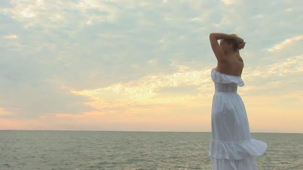 Mujer en vestido blanco en la playa — Vídeo de stock