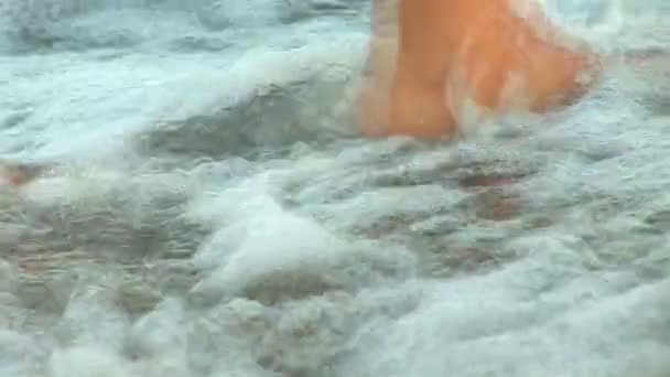 Mujer vestida de blanco caminando sobre las olas — Vídeo de stock