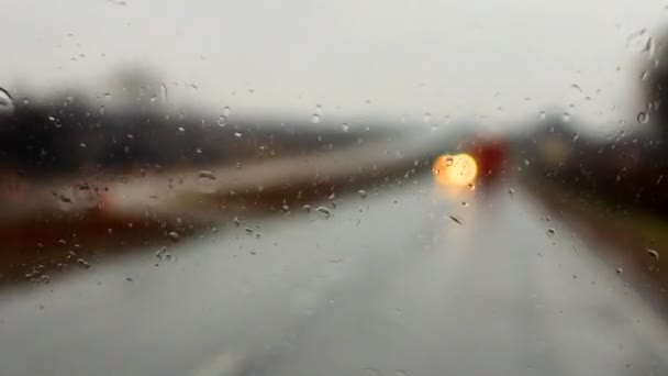 Araba ön cam üzerinde yağmur damlaları — Stok video