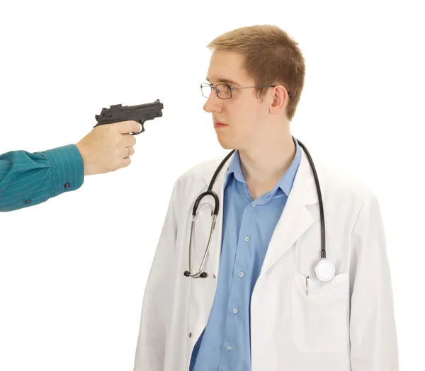 Uma pessoa segura o jovem médico com uma arma apontada — Fotografia de Stock