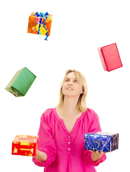 Woman juggling with some colorful gifts — Stock Photo, Image