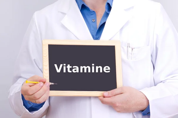 Arzt zeigt Informationen auf Tafel: Vitamine — Stockfoto