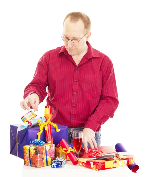 Человек упаковки некоторые красочные подарки — стоковое фото
