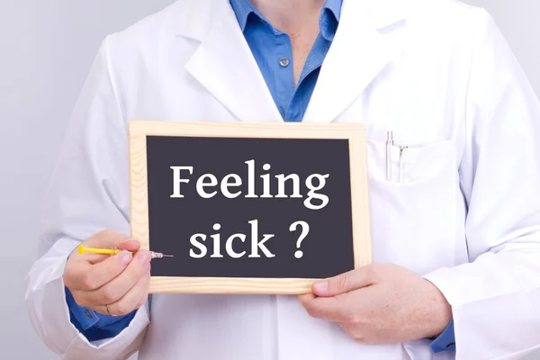 Doctor shows information on blackboard: feeling sick? — Stock Photo, Image