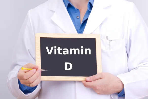Arzt zeigt Informationen auf Tafel: Vitamin D Stockfoto