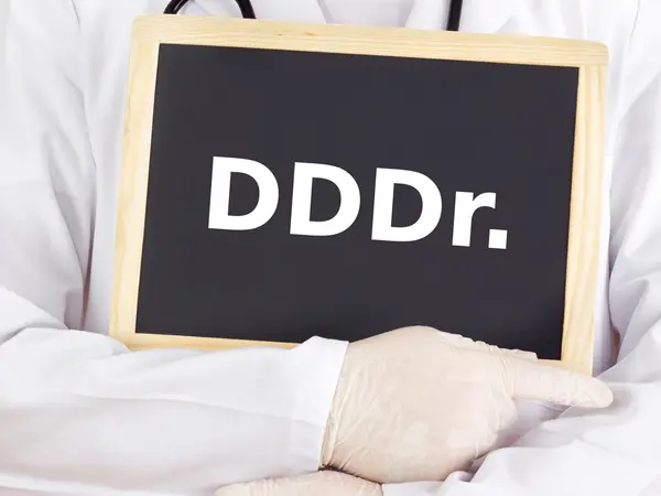 Doctor shows information on blackboard: dddr — Stock Photo, Image