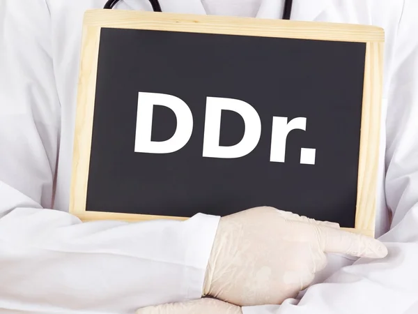 Doctor shows information on blackboard: ddr — Stock Photo, Image