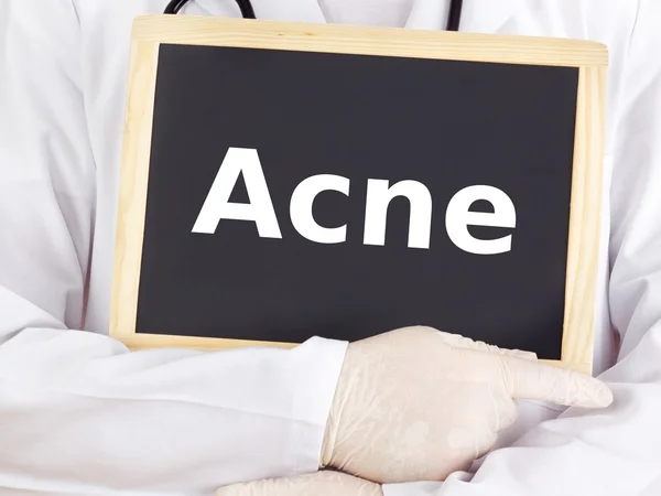 Doctor shows information on blackboard: acne — Stock Photo, Image
