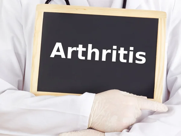 Doctor shows information on blackboard: arthritis — Stock Photo, Image