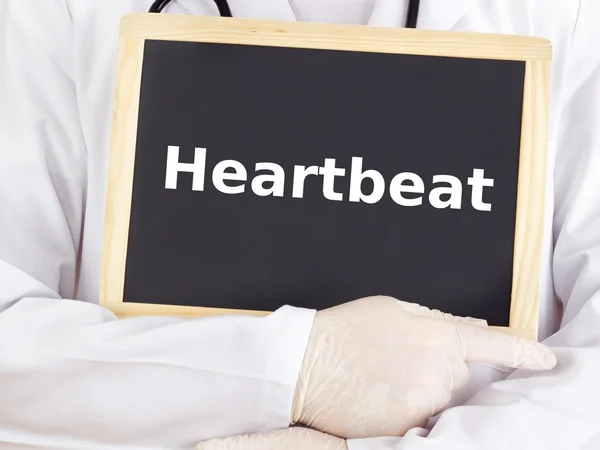 Doctor shows information on blackboard: heartbeat — Stock Photo, Image