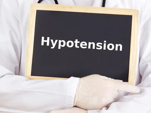 Doctor shows information on blackboard: hypotension — Stock Photo, Image