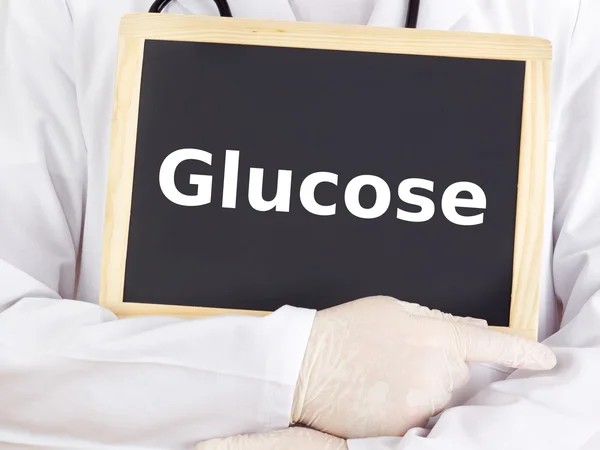 Doctor shows information on blackboard: glucose — Stock Photo, Image