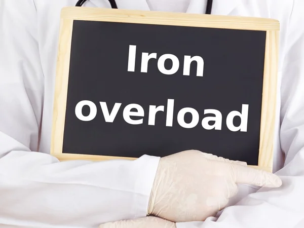 Doctor shows information on blackboard: iron overload — Stock Photo, Image