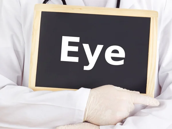 Doctor shows information on blackboard: eye — Stock Photo, Image