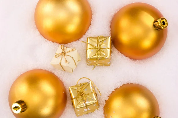 Bolas de árbol de Navidad y regalos en nieve — Foto de Stock