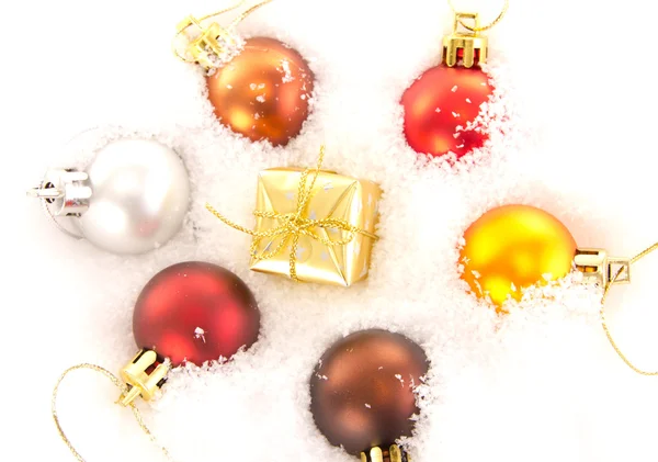 Christmas tree balls and gift in snow — Stock Photo, Image