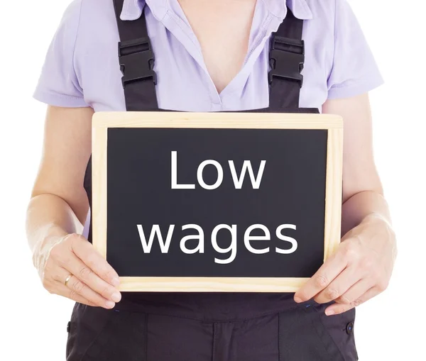 Craftsperson with blackboard: low wages — Stock Photo, Image
