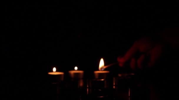 Velas encendidas sobre un fondo oscuro — Vídeo de stock