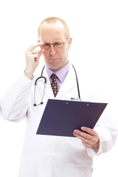 Ärztin blickt besorgt auf Patientenakte — Stockfoto
