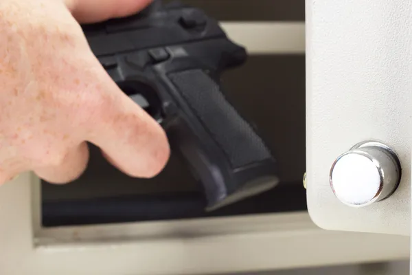 Persona che mette un'arma da fuoco in cassaforte — Foto Stock