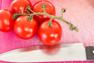 doğrama kurulu üzerinde mutfak bıçağı ile güzel domates