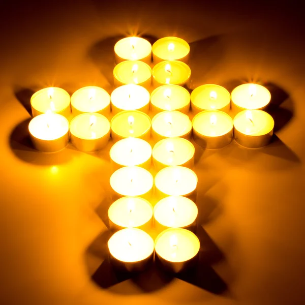 Croix chrétienne faite de bougies de thé — Photo
