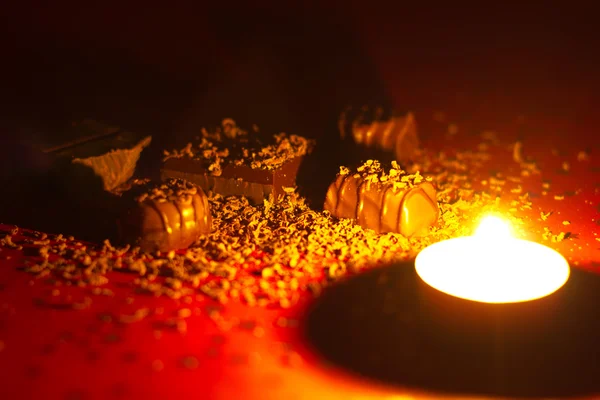 Comer deliciosos pralinés hechos a la luz de las velas — Foto de Stock