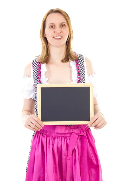 Vrouw in dirndl toont blanco schoolbord — Stockfoto